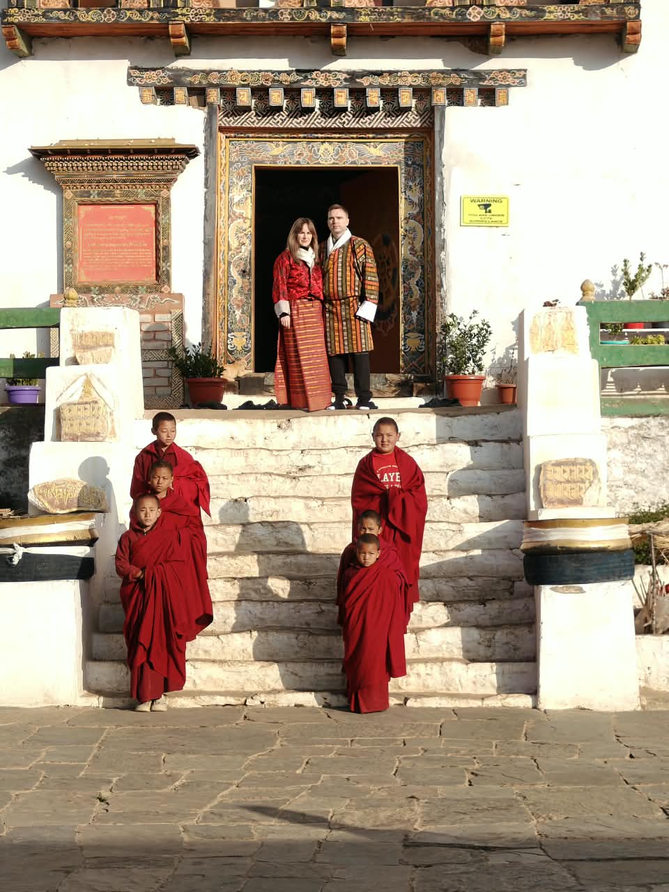 Lhayul Bhutan Adventures - International Guests in Traditional Bhutanese Dress with Young Monks